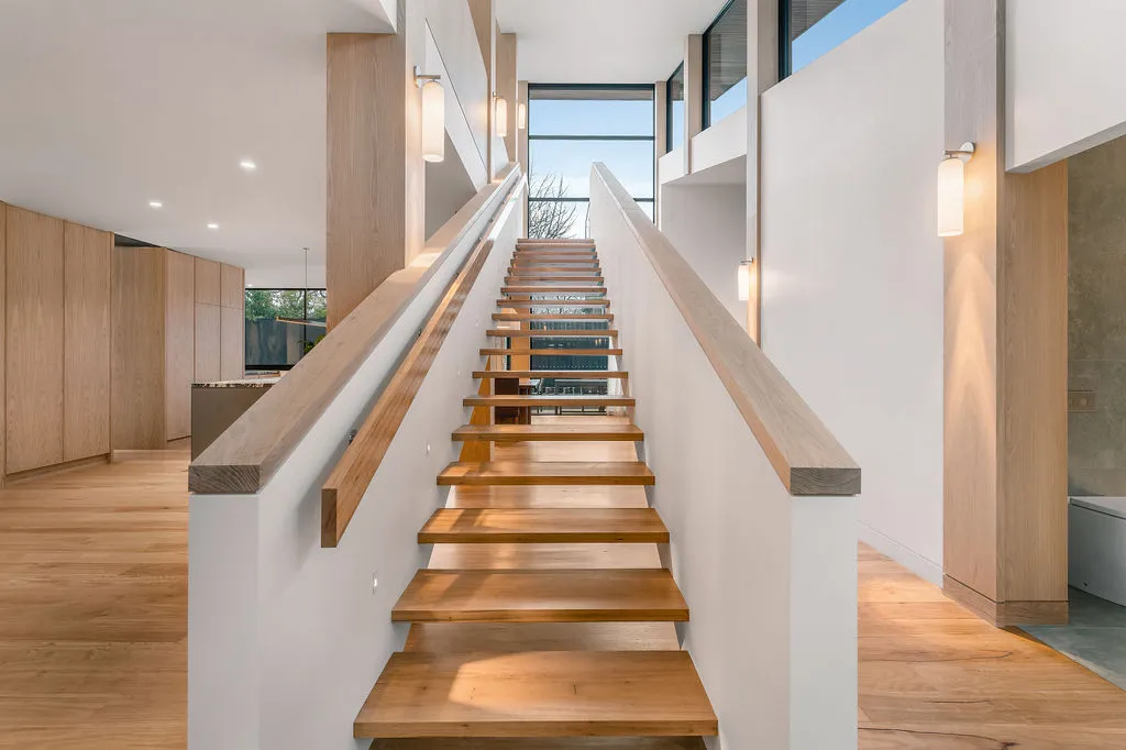 Modern open timber staircase with white walls, pendant lighting and oak flooring