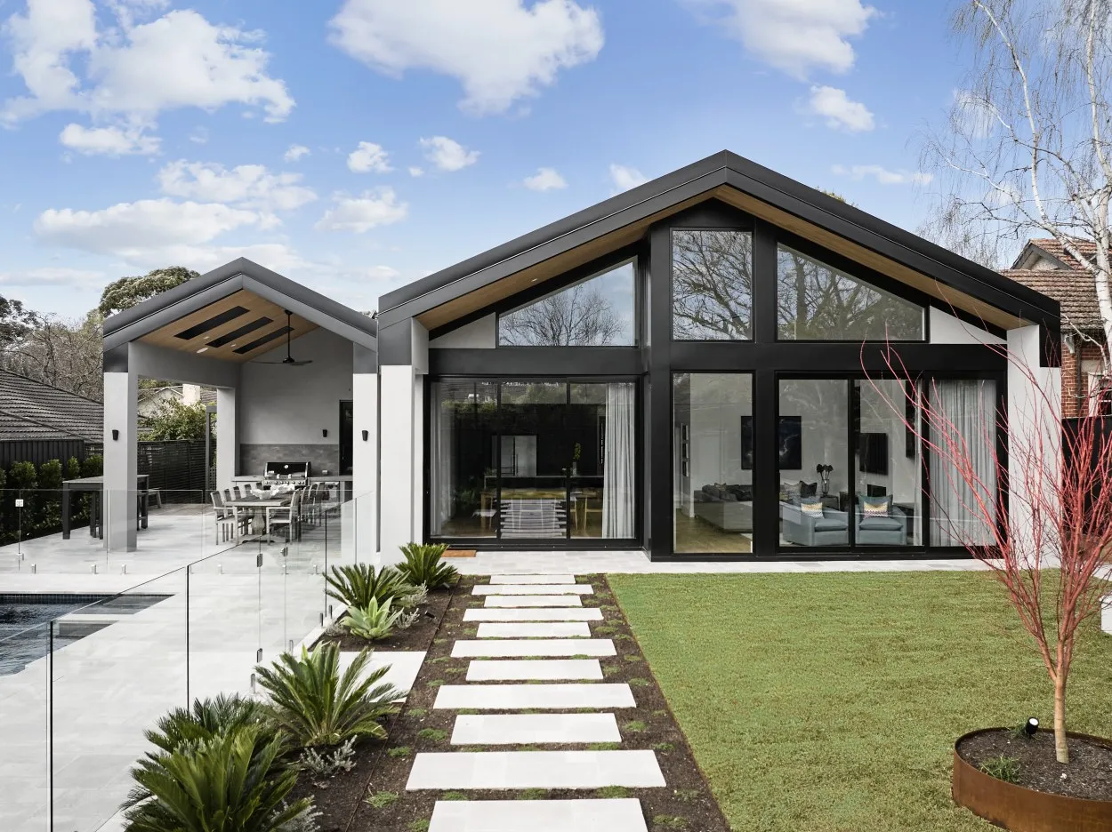 Double gable home rear view with floor-to-ceiling glazing, garden path and alfresco