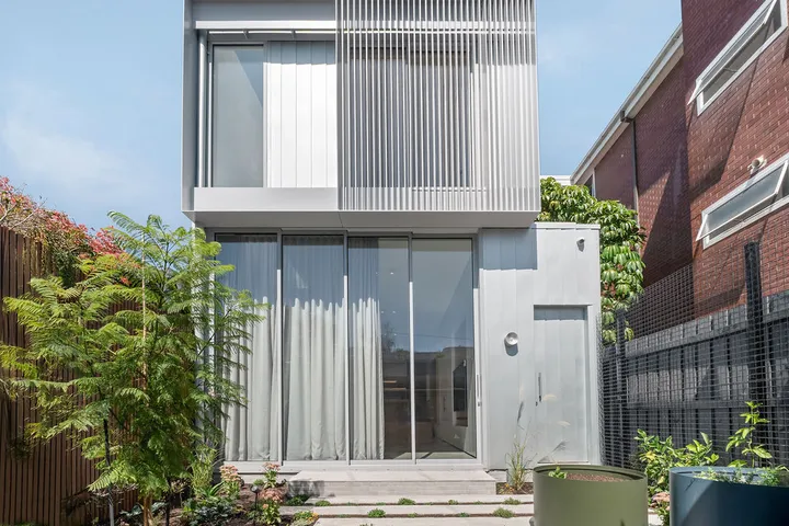 Two-storey terrace home exterior with aluminium louvre screen and glass sliding doors