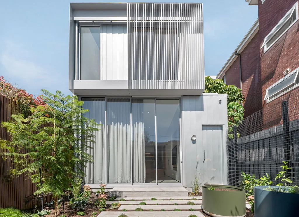 Two-storey terrace home exterior with aluminium louvre screen and glass sliding doors