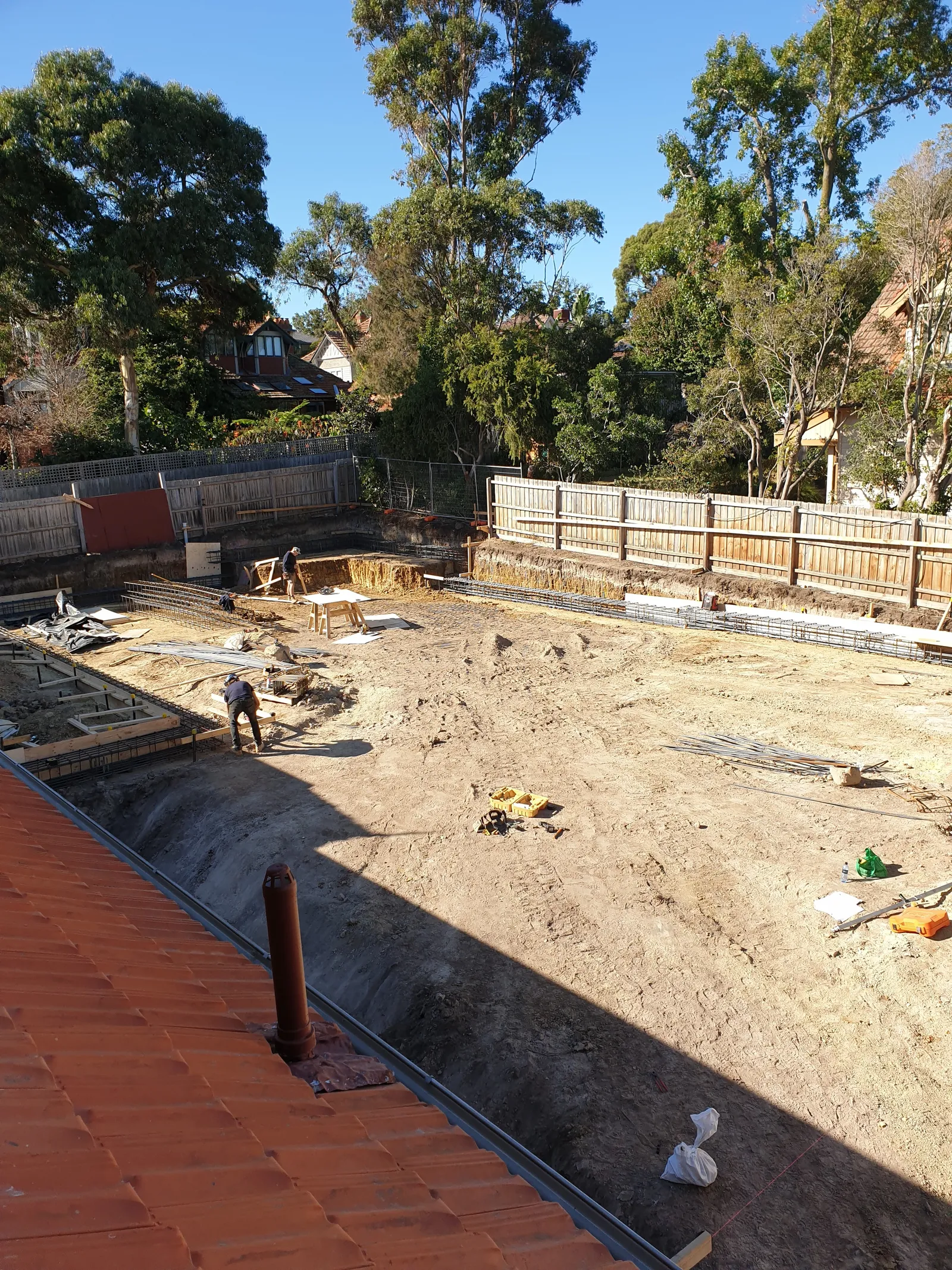 Basement excavation site from above with shoring and site protection in place