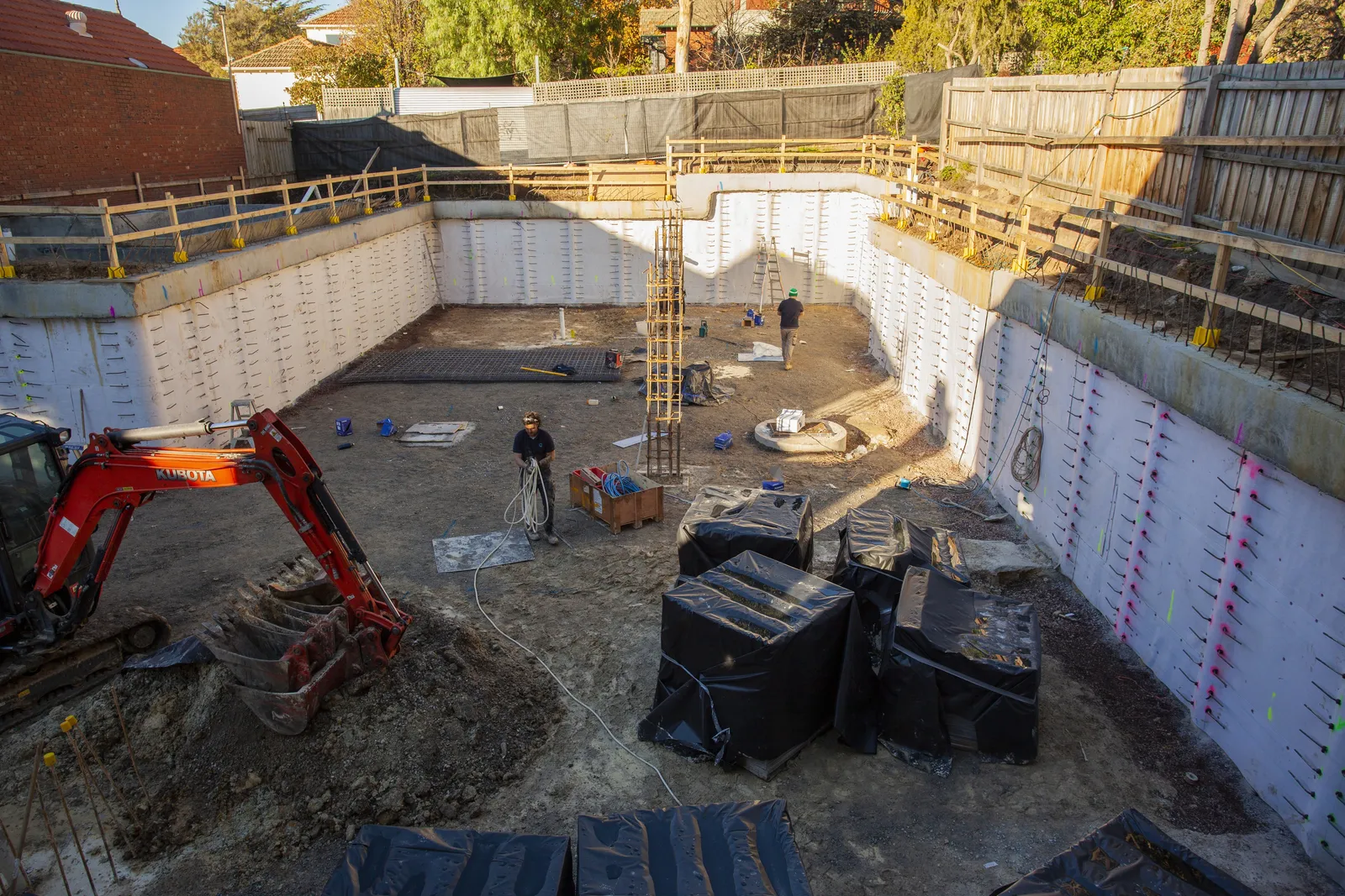 Excavator working inside a retained basement excavation on a tight suburban site