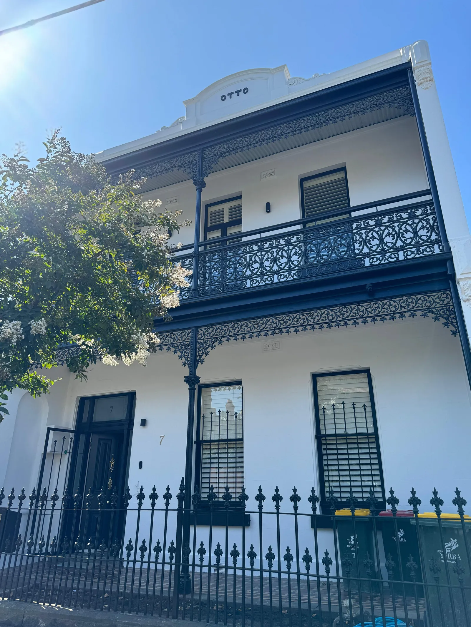 Two storey Victorian terrace facade with iron lacework balcony and picket fence