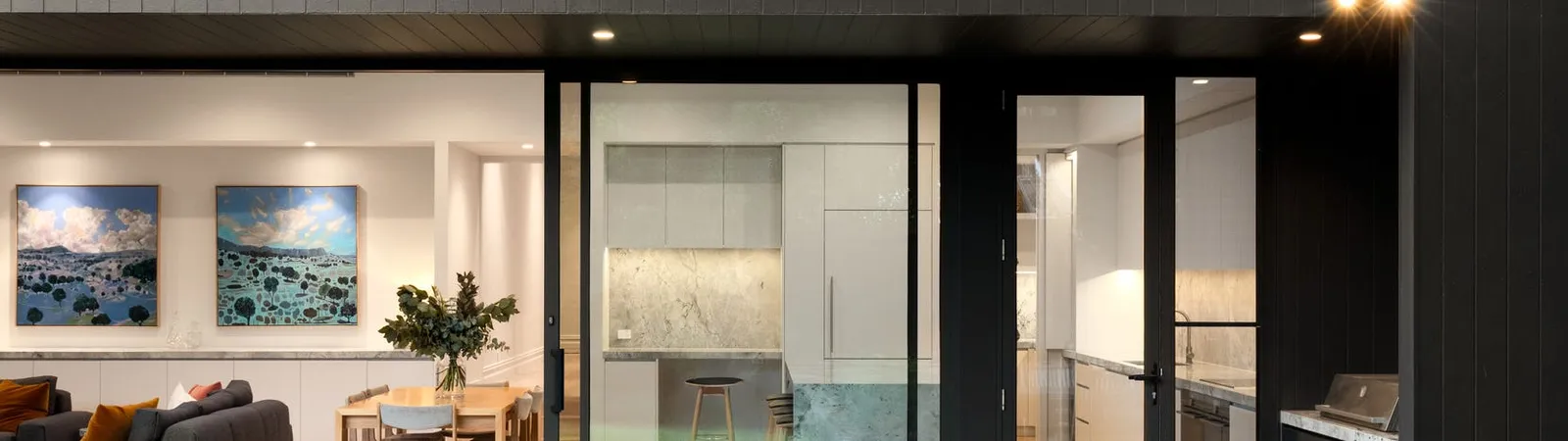 Rear extension at twilight with lit interiors and garden seating