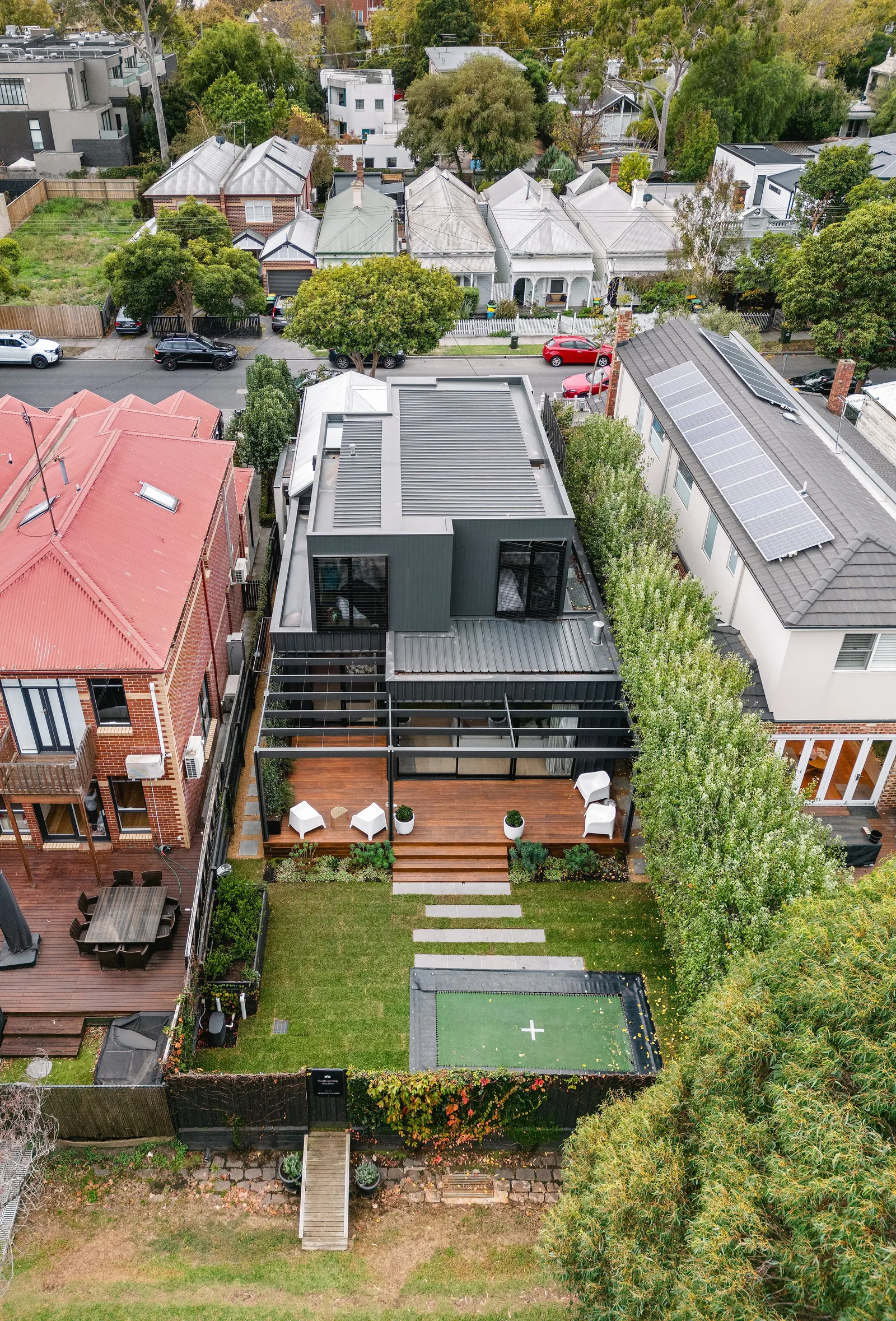 Aerial view of the renovated home with rooftop deck and rear addition