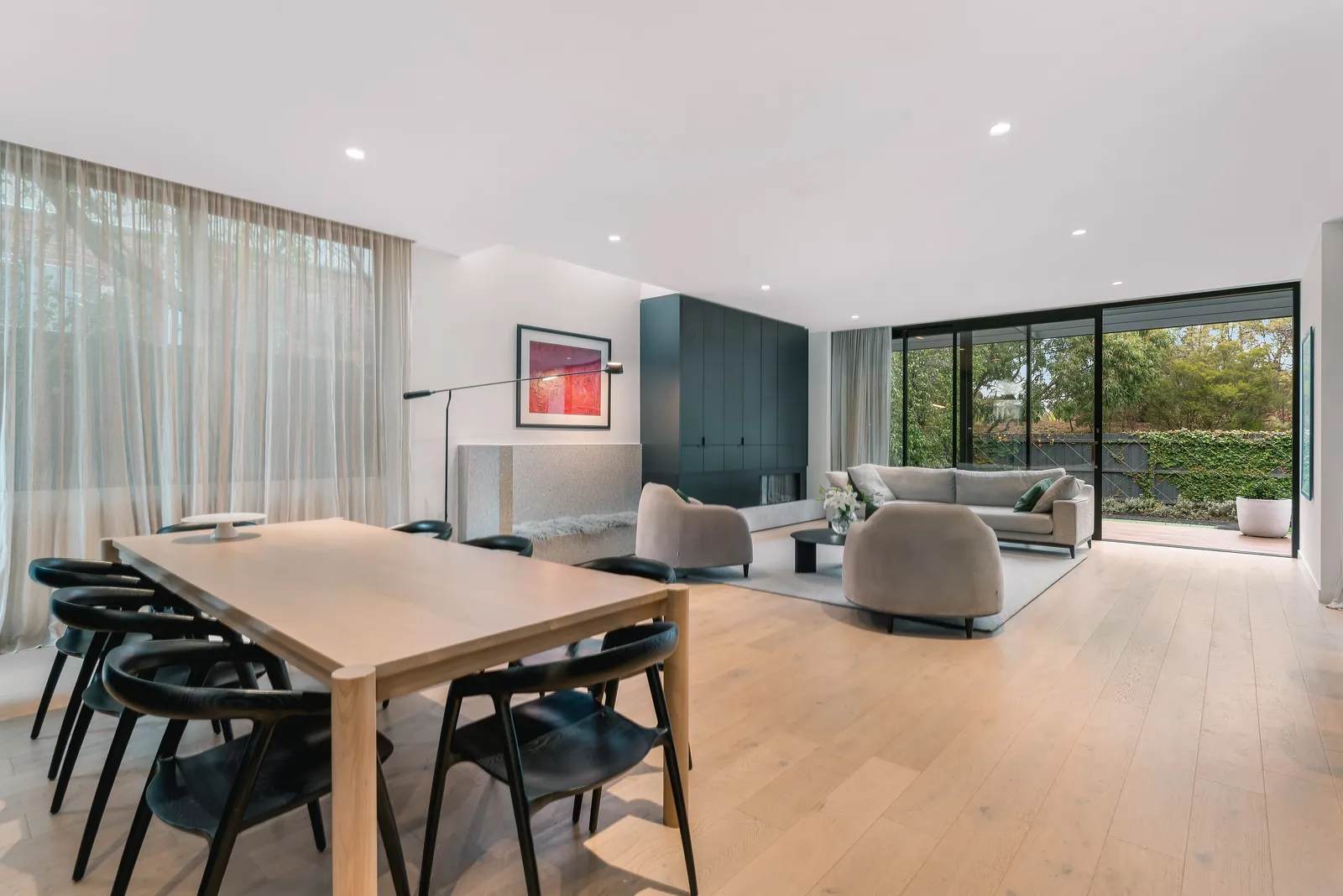 Open plan dining and living with timber table and pale sofas