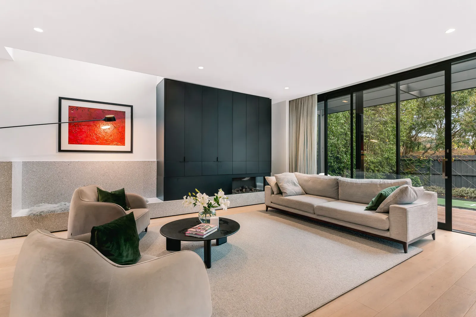 Living room with black joinery wall and garden glazing