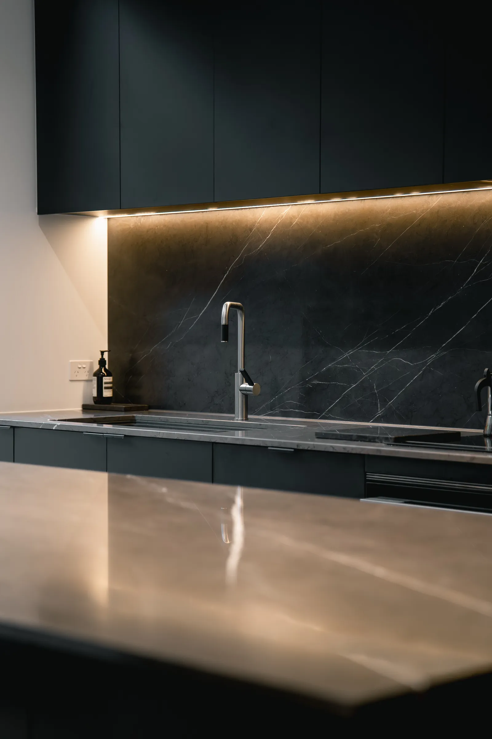 Close-up of dark stone splashback with under-cabinet lighting