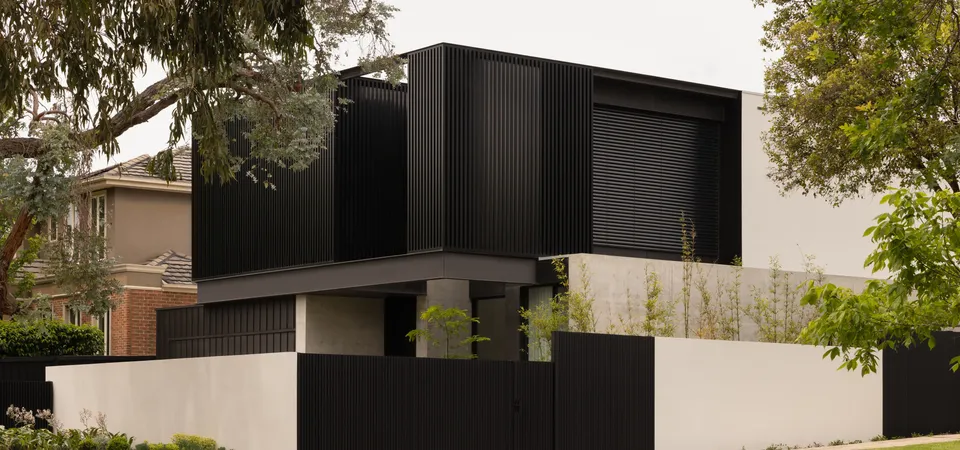Contemporary two-storey luxury home exterior with black vertical cladding and white rendered walls