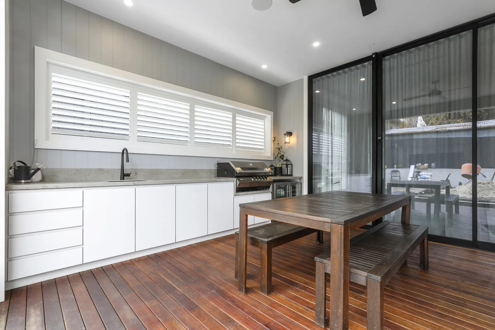 Covered alfresco with outdoor kitchen, timber deck and dining table