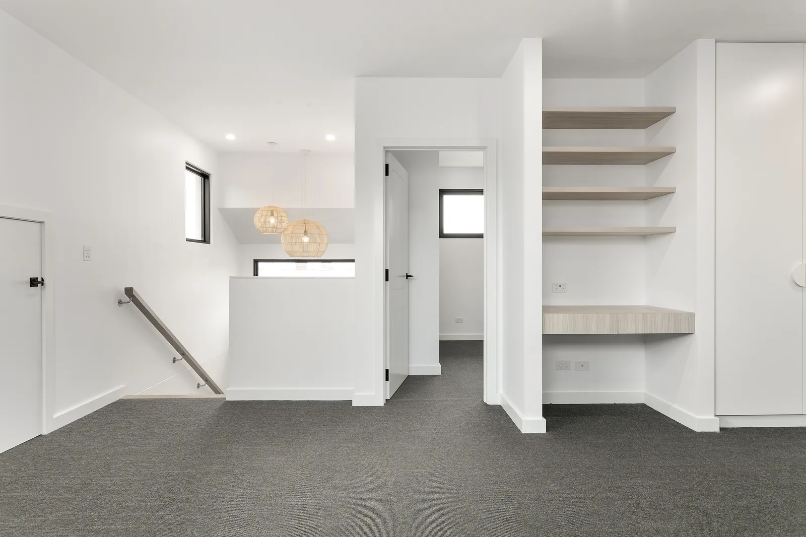 Upstairs retreat with built-in desk, open shelving and stair void