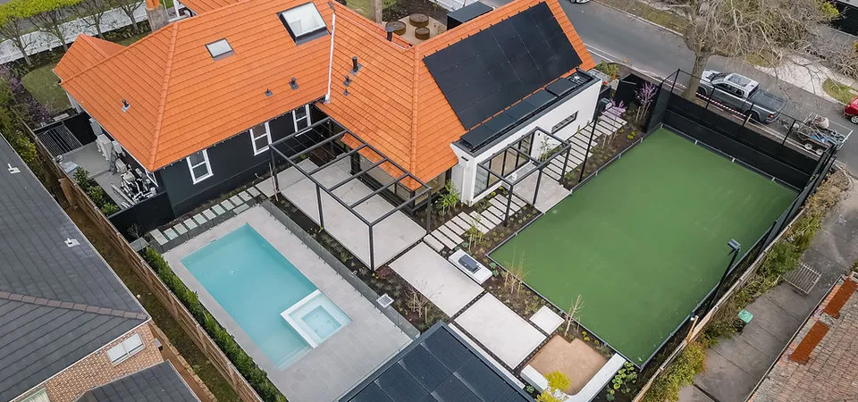 Aerial view of heritage home with terracotta roof, pool, tennis court and solar panels