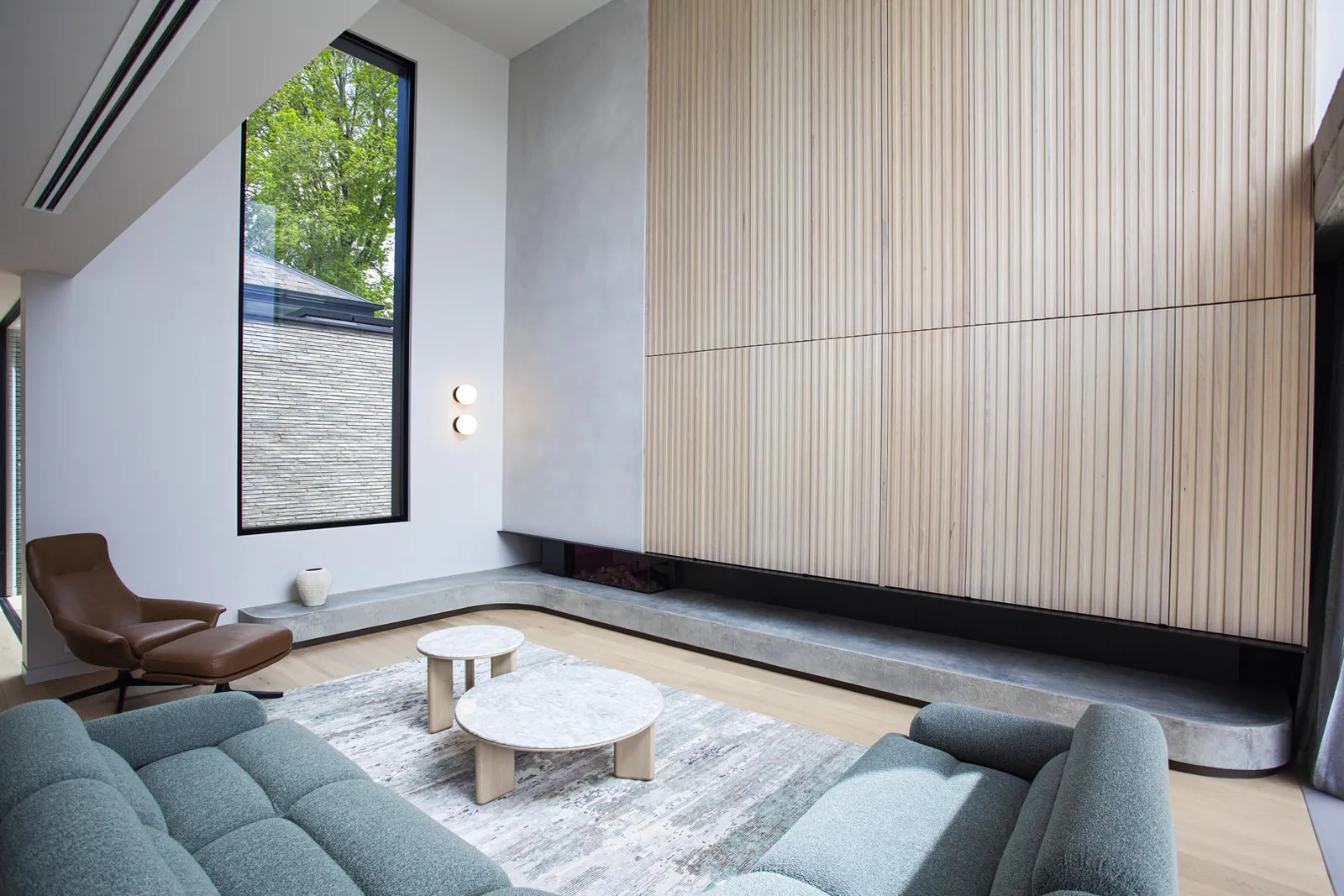 Double-height living room with timber slat feature wall, linear fireplace, and tall glazed window