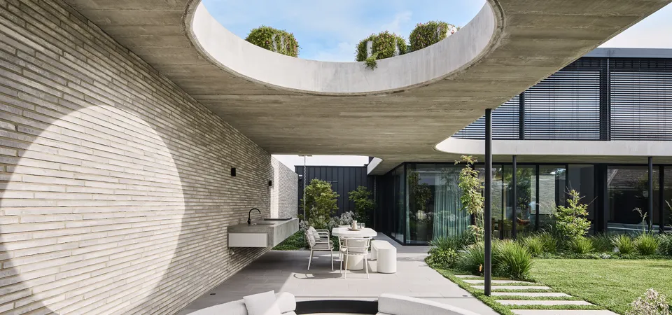 Outdoor entertaining area with circular concrete ceiling void, curved lounge seating and garden courtyard