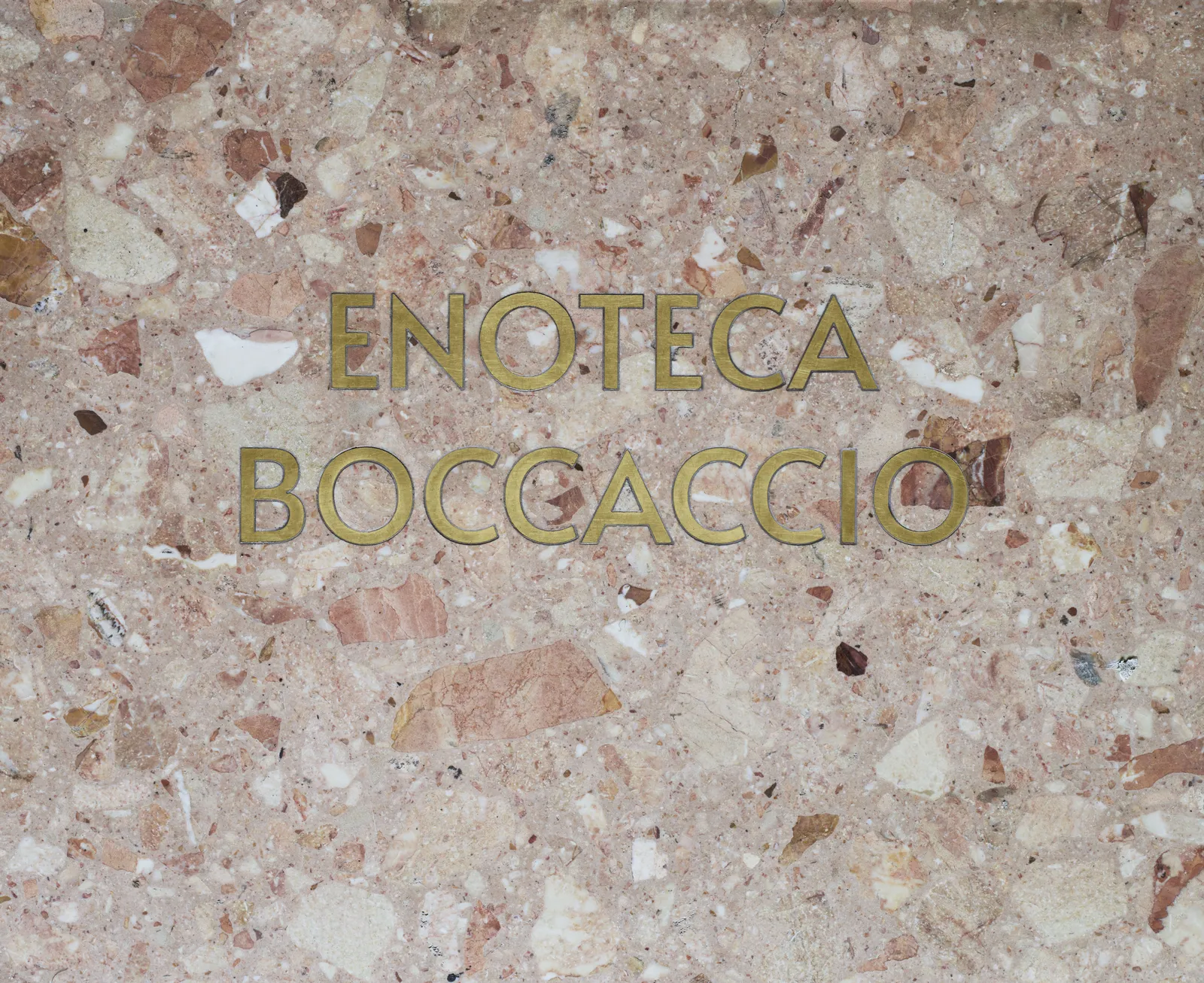 Enoteca Boccaccio name inlaid in brass lettering on terrazzo surface
