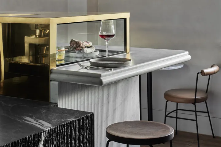 Enoteca Boccaccio restaurant bar counter with brass display case, marble top, and bar stools